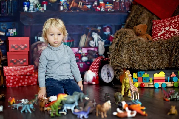 Dulce niño rubio, jugando con animales de plástico y dinos —  Fotos de Stock