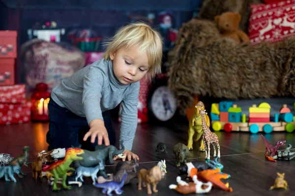 Dulce niño rubio, jugando con animales de plástico y dinos —  Fotos de Stock