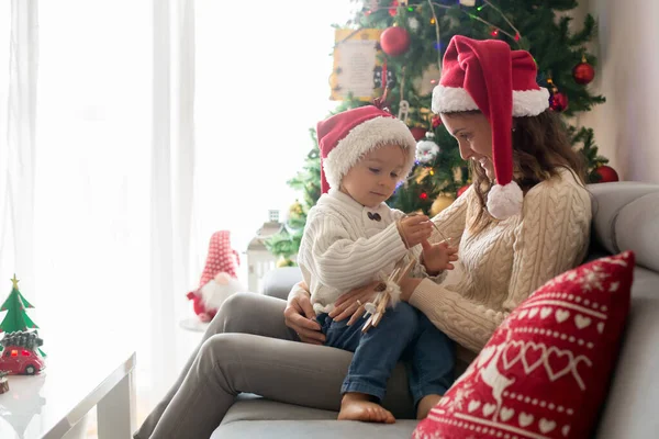 Schöne junge Mutter und blonde Kleinkind Junge, sitzt in gemütlichen livi — Stockfoto