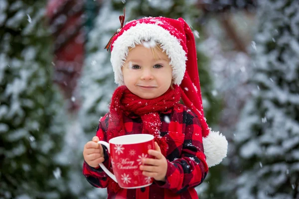 Doux beau tout-petit garçon, tenant tasse avec du lait chaud, boire — Photo