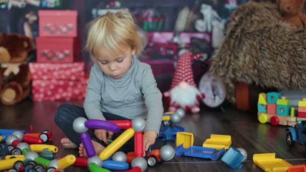 Sweet Blonde Toddler Boy Playing Plastic Construction Making Different Shapes — Stock Video