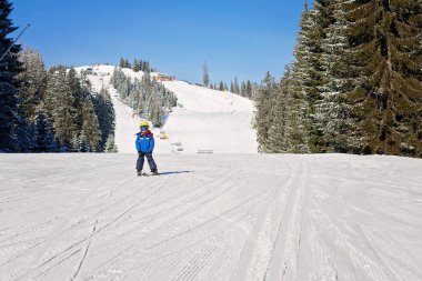 Sevimli küçük çocuk, mutlu bir şekilde Kayak Avusturya Kayak beldesinde mo