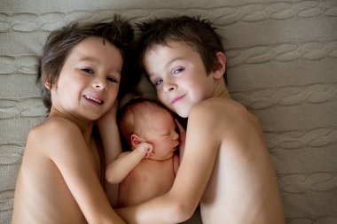 İki çocuk, yürümeye başlayan çocuk ve onun büyük kardeşi, sarılma ve öpüşme t