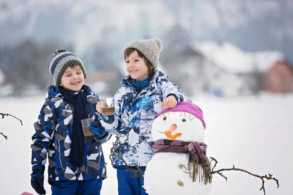 Famiglia con bambini, costruzione pupazzo di neve nel parco in poco male — Foto Stock