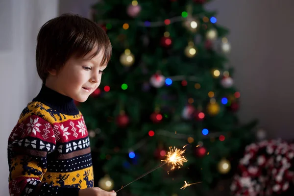 Krásné malé dítě drží hořící prskavka na nový rok Ev — Stock fotografie