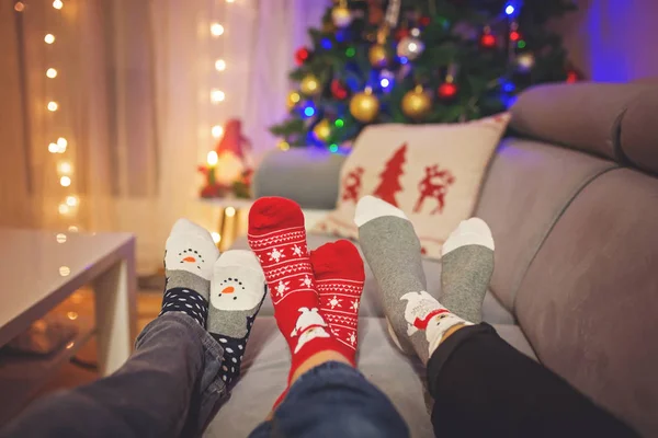 Vier Paar Füße in Weihnachtssocken, Mutter und Kinder liegen auf — Stockfoto