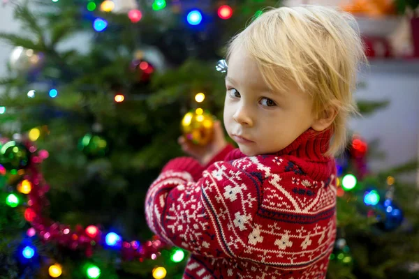 Cute little blonde boy with Christmas sweater, decorating christ — Stock Photo, Image