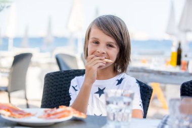 Sevimli okul öncesi çocuk, restoranda oturan, outdo pizza yemek