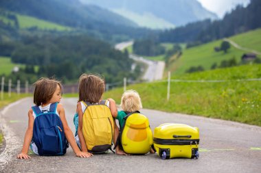Küçük çocuklar, sırt çantaları ve sutcase ile erkek kardeşler, seyahat