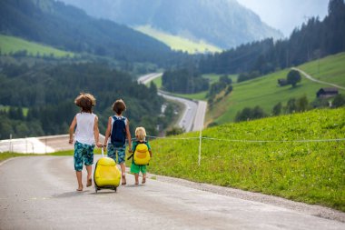 Küçük çocuklar, sırt çantaları ve sutcase ile erkek kardeşler, seyahat