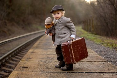 Tren istasyonunda tatlı bir çocuk, Su ile birlikte treni bekliyor.