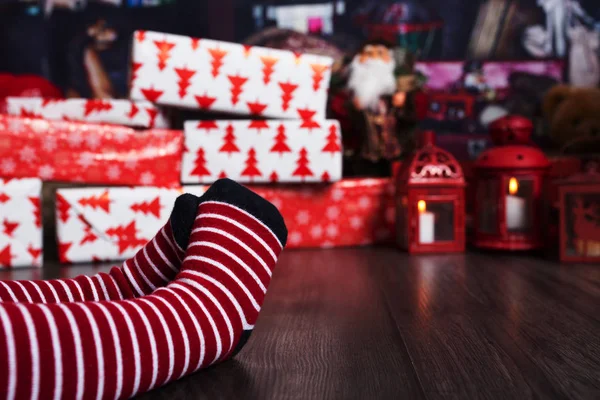 Voeten met kerstsokken op de ruit. Moeder en kind zitten — Stockfoto