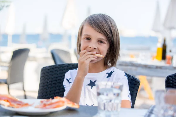 可爱的学龄前男孩，坐在餐厅里，吃披萨 — 图库照片