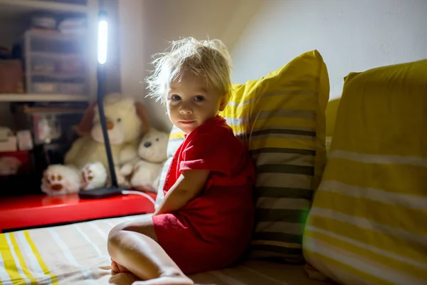 Tatlı çocuk, yatağında oturuyor, gece uykusu için hazırlanıyor. — Stok fotoğraf
