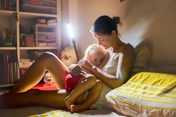 Mamma, amning hennes småbarn pojke hemma på natten, Night St — Stockfoto