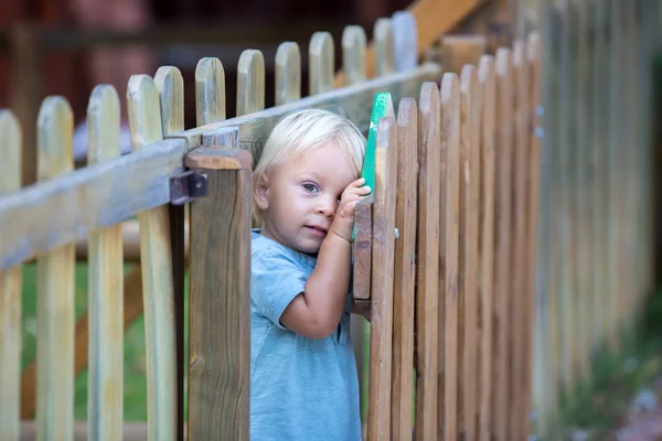 Liten småbarn pojke, leker på lekplatsen sommartid, swingi — Stockfoto