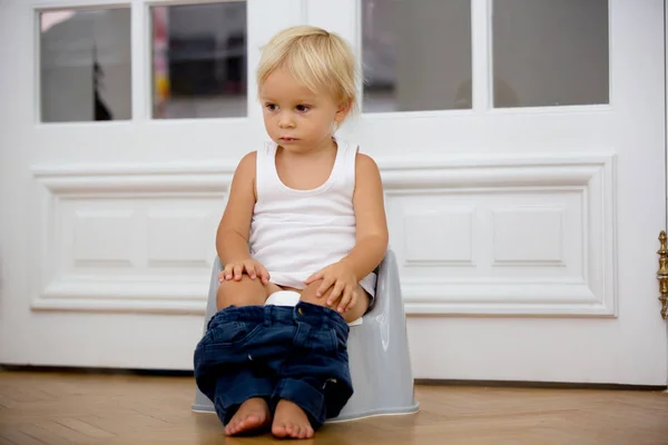 Infant child baby boy toddler sitting on potty, playing with toy — Stock Photo, Image