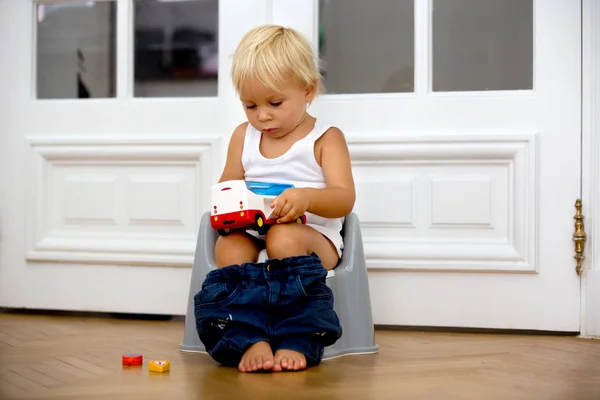 장난감을 가지고 놀고, 변기 위에 앉아있는 유아 아기 소년 유아 — 스톡 사진