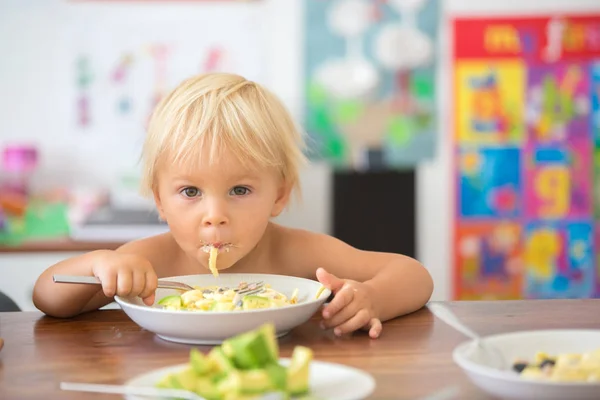 Dulce niño, comiendo espaguetis en casa, haciendo un lío y h — Foto de Stock