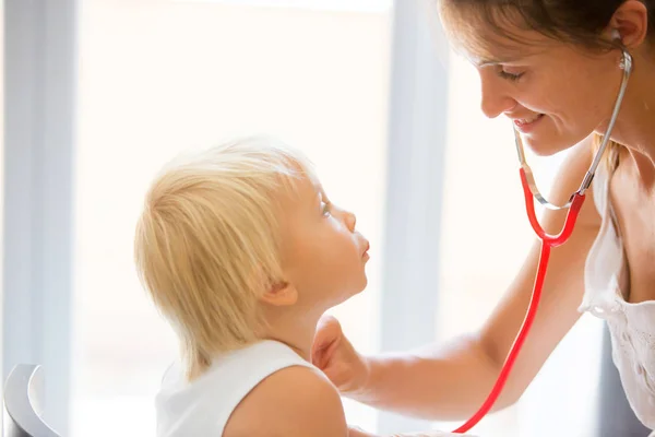 Kinderarts onderzoek baby jongen. Arts die stethoscoop naar Lis gebruikt — Stockfoto