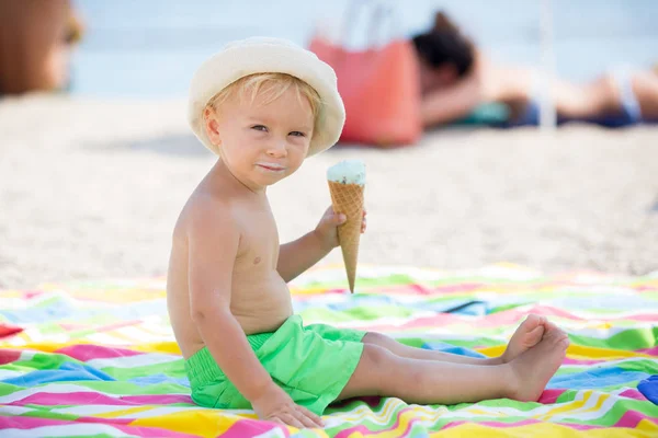 Dulce niño rubio, eaiting helado en la playa — Foto de Stock