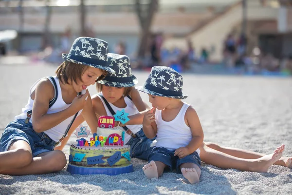 Sweet boys, celebrating on the beach birthday with car theme cak — Stock Photo, Image