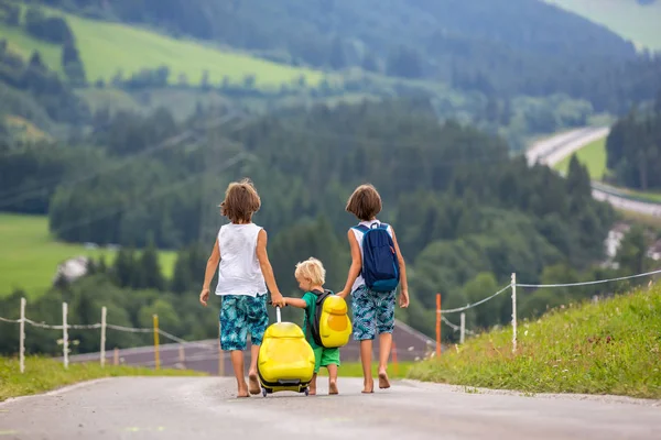 Küçük çocuklar, sırt çantaları ve sutcase ile erkek kardeşler, seyahat
