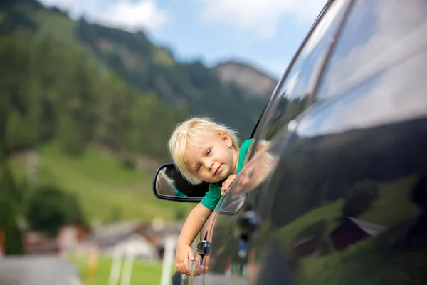 かわいい子供、車の窓から見て男の子、への道を旅 — ストック写真