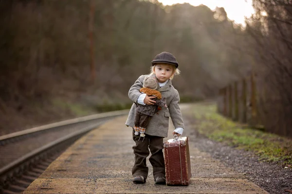 Uroczy chłopiec na dworcu kolejowym, czeka na pociąg z su — Zdjęcie stockowe