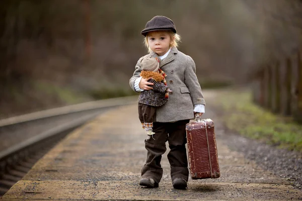 Adorable garçon sur une gare, attendant le train avec su — Photo