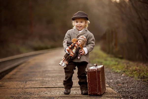 Adorable niño en una estación de tren, esperando el tren con su —  Fotos de Stock