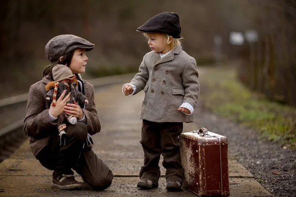 Adoráveis meninos em uma estação ferroviária, esperando o trem com s — Fotografia de Stock