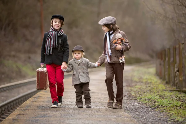 Entzückende Jungen auf einem Bahnhof und warten auf den Zug mit s — Stockfoto