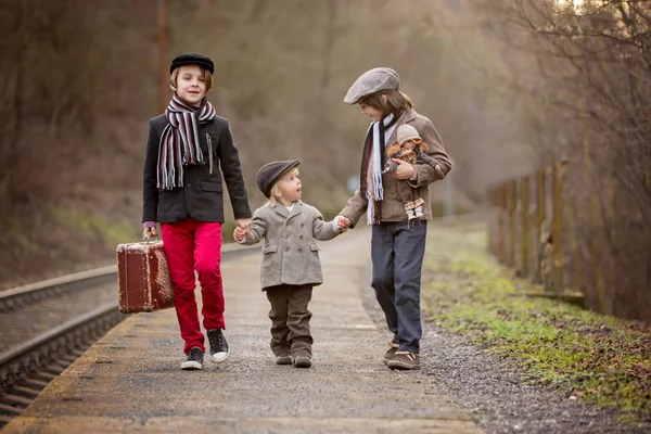 Adoráveis meninos em uma estação ferroviária, esperando o trem com s — Fotografia de Stock