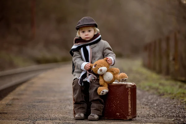 Adorable boy on a railway station, waiting for the train with su — 스톡 사진