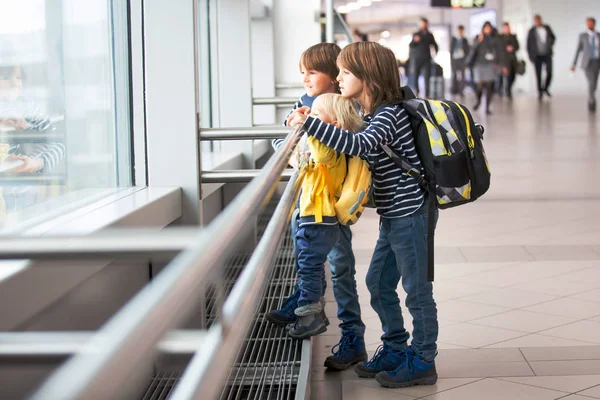 Söt pojke väntar ombordstigning på flyg i flygplatsen transit hal — Stockfoto