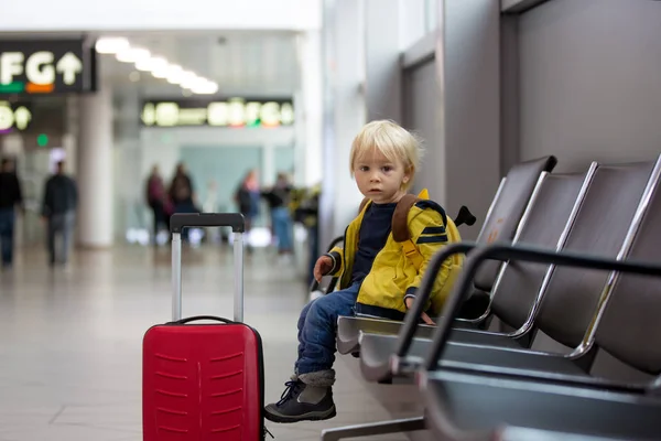 Netter kleiner Junge wartet auf den Flug in der Transithalle des Flughafens — Stockfoto