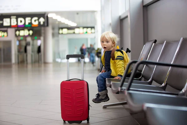 Netter kleiner Junge wartet auf den Flug in der Transithalle des Flughafens — Stockfoto
