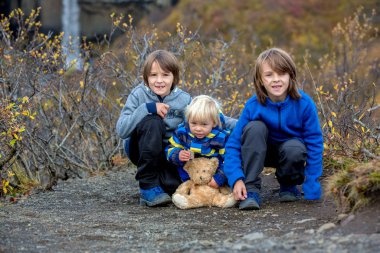 Mutlu çocuklar, Svartifos şelalesinin önünde poz veriyorlar.