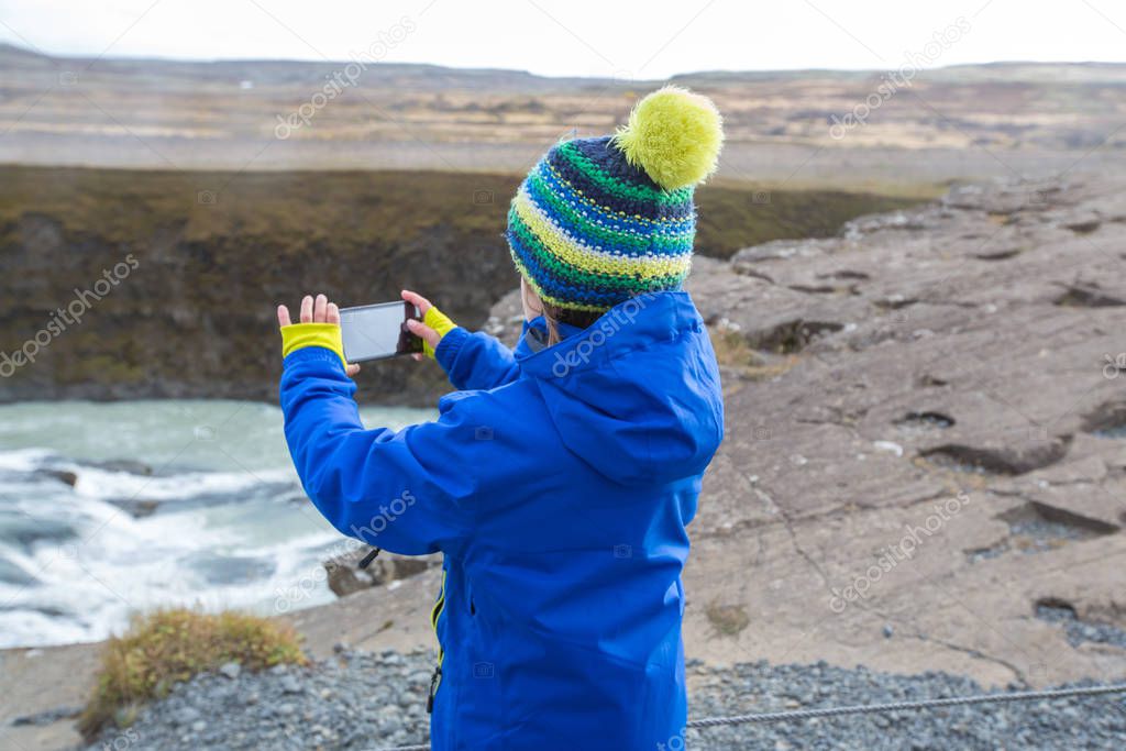 Children, enjoying the big majestic Gullfoss waterfall in mounta