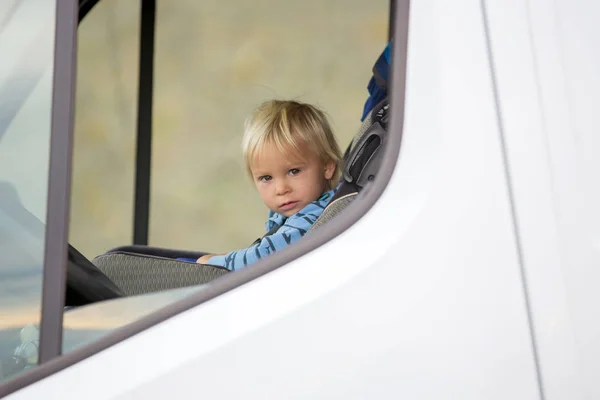 かわいい幼児の男の子、子供はチャイルドシートの前の席に座っている — ストック写真