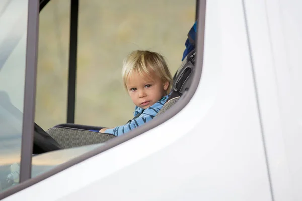 Söta småbarn pojke, unge sitter på framsätet i barnstol på — Stockfoto