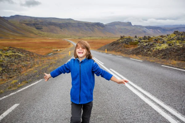 Kid correndo em uma estrada vazia na bela natureza em Snaefellsjok — Fotografia de Stock