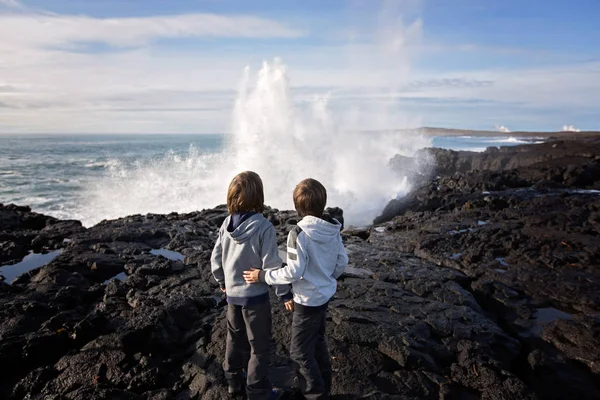 Children watching big waves crashing in rocks on the south west — 스톡 사진