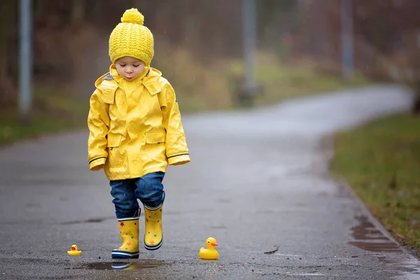 Beautiful funny blonde toddler boy with rubber ducks and colorfu — Stock Photo, Image