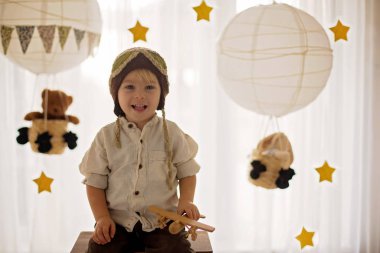 Sweet toddler boy, playing with airplane and teddy bear, air bal