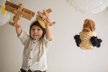 Sweet toddler boy, playing with airplane and teddy bear, air bal
