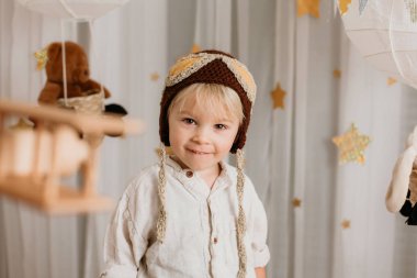 Sweet toddler boy, playing with airplane and teddy bear, air bal