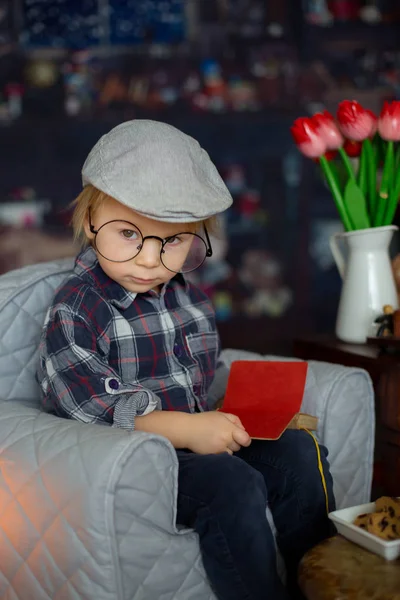 甘い幼児の男の子、眼鏡をかけ、本を読んで飲んで — ストック写真