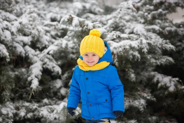 Süßer kleiner Junge, der auf Spielplatz mit Schnee spielt — Stockfoto